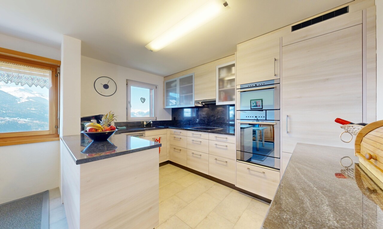 cuisine avec péninsule de cuisine, kitchen peninsula, armoires avec insert en verre, glass insert cabinets, et dark countertops