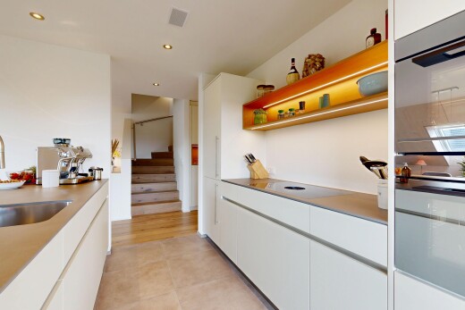 küche mit doppel backofen, weiße schränke, schränke mit flachen paneelen, waschbecken, und gipskartonwand