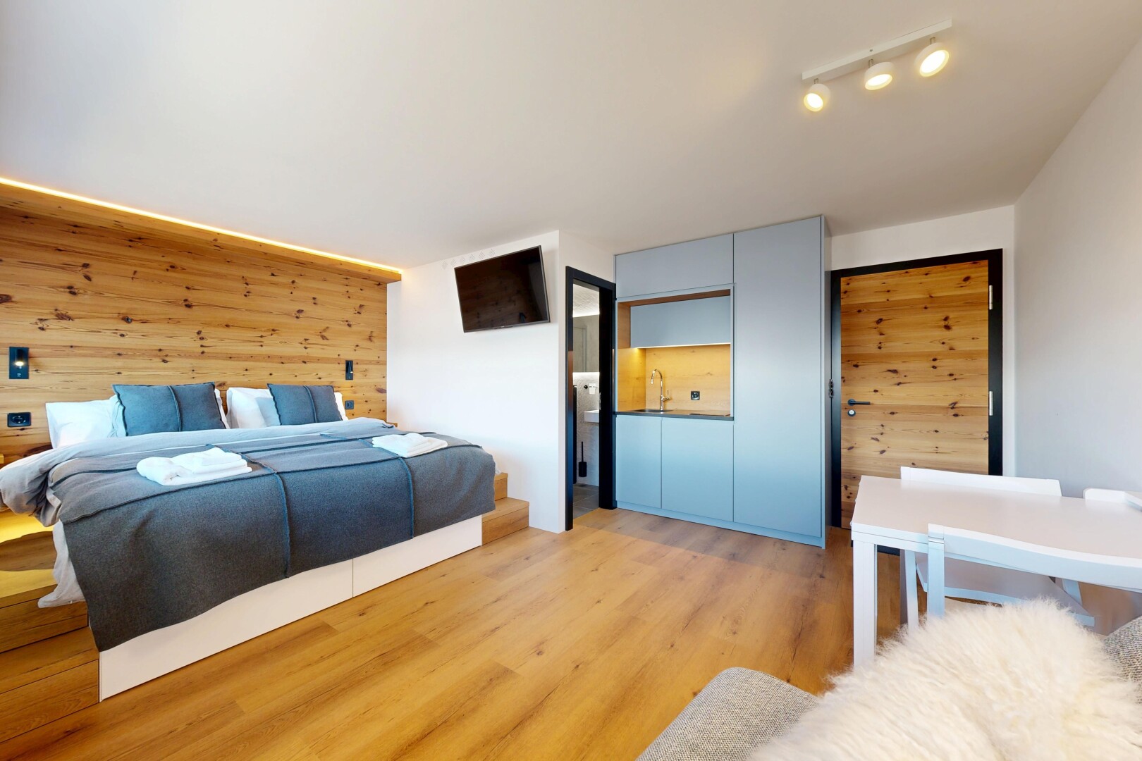 zimmer / schlafzimmer mit wood wall, holzwand, inside property, wood finish floor, und holzfußboden