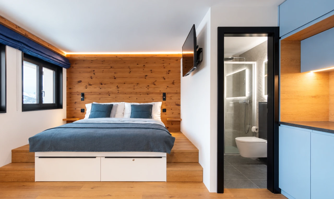 zimmer / schlafzimmer mit gipskartonwand, drywall, fernseher, light floor, und holzwand