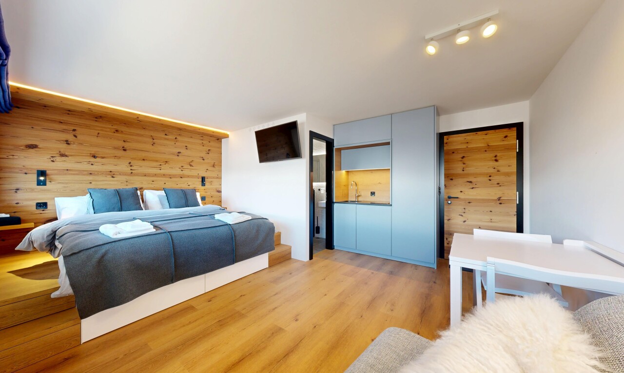 zimmer / schlafzimmer mit wood wall, holzwand, inside property, wood finish floor, und holzfußboden
