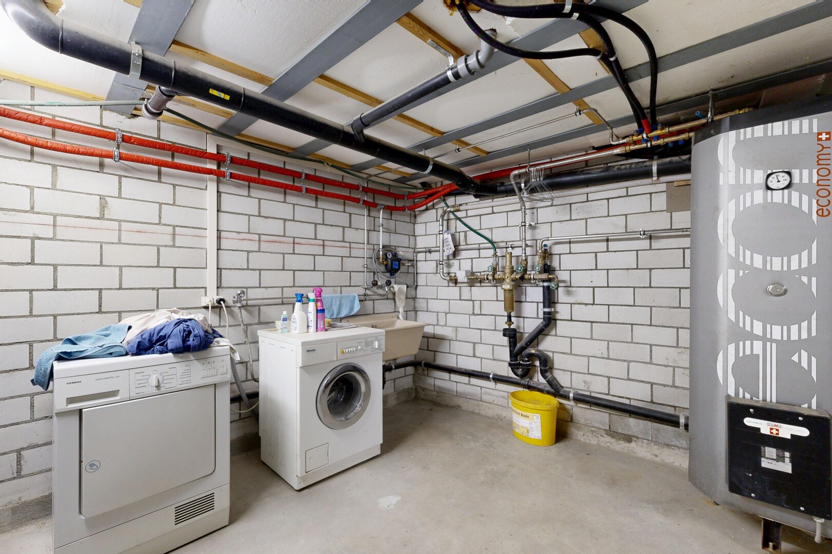 buanderie avec sol en béton, concrete floor, inside property, buanderie, et lave-linge et sèche-linge séparés
