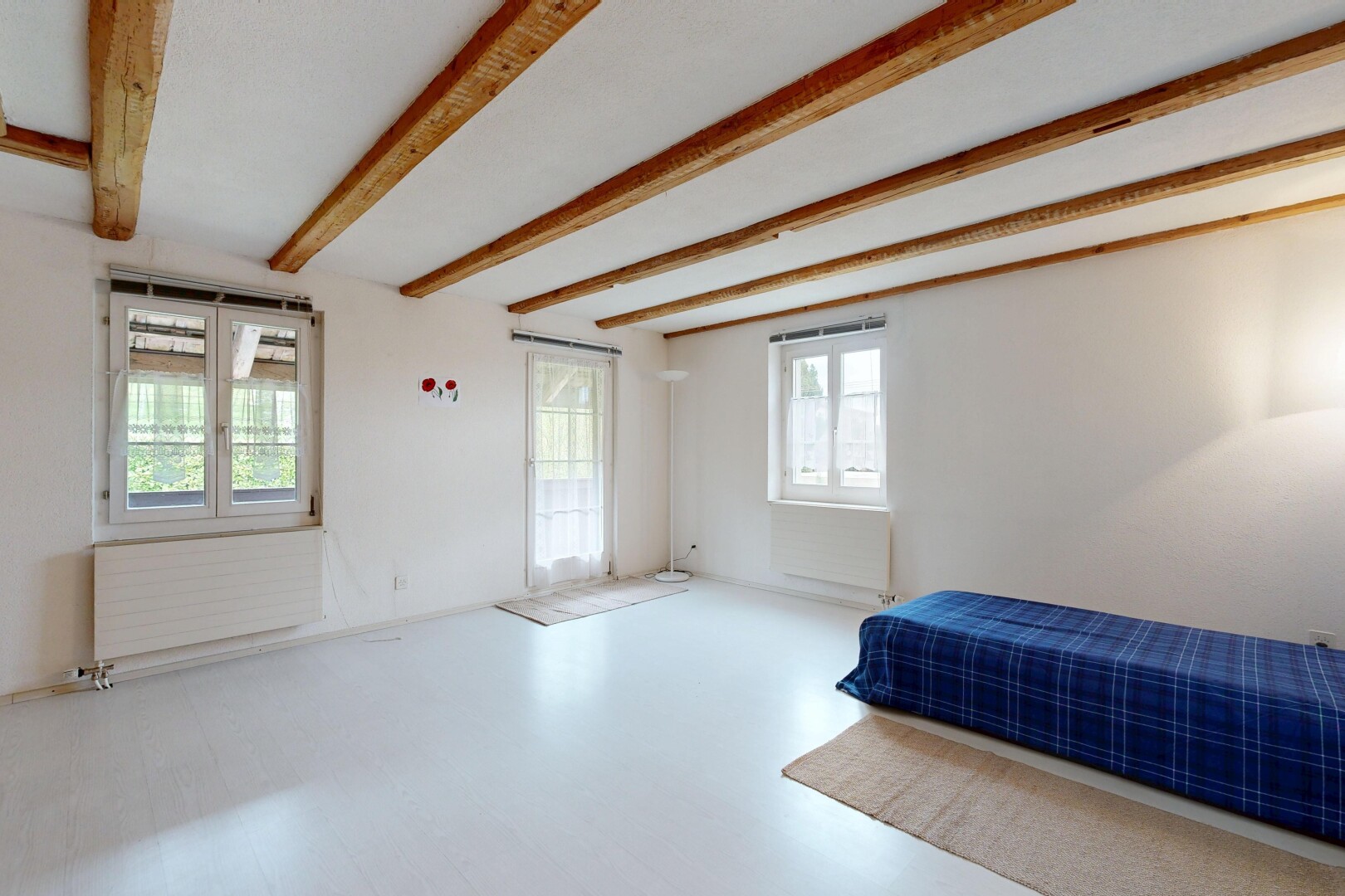 chambre avec inside property, beamed ceiling, plafond à poutres, drywall, et cloison sèche