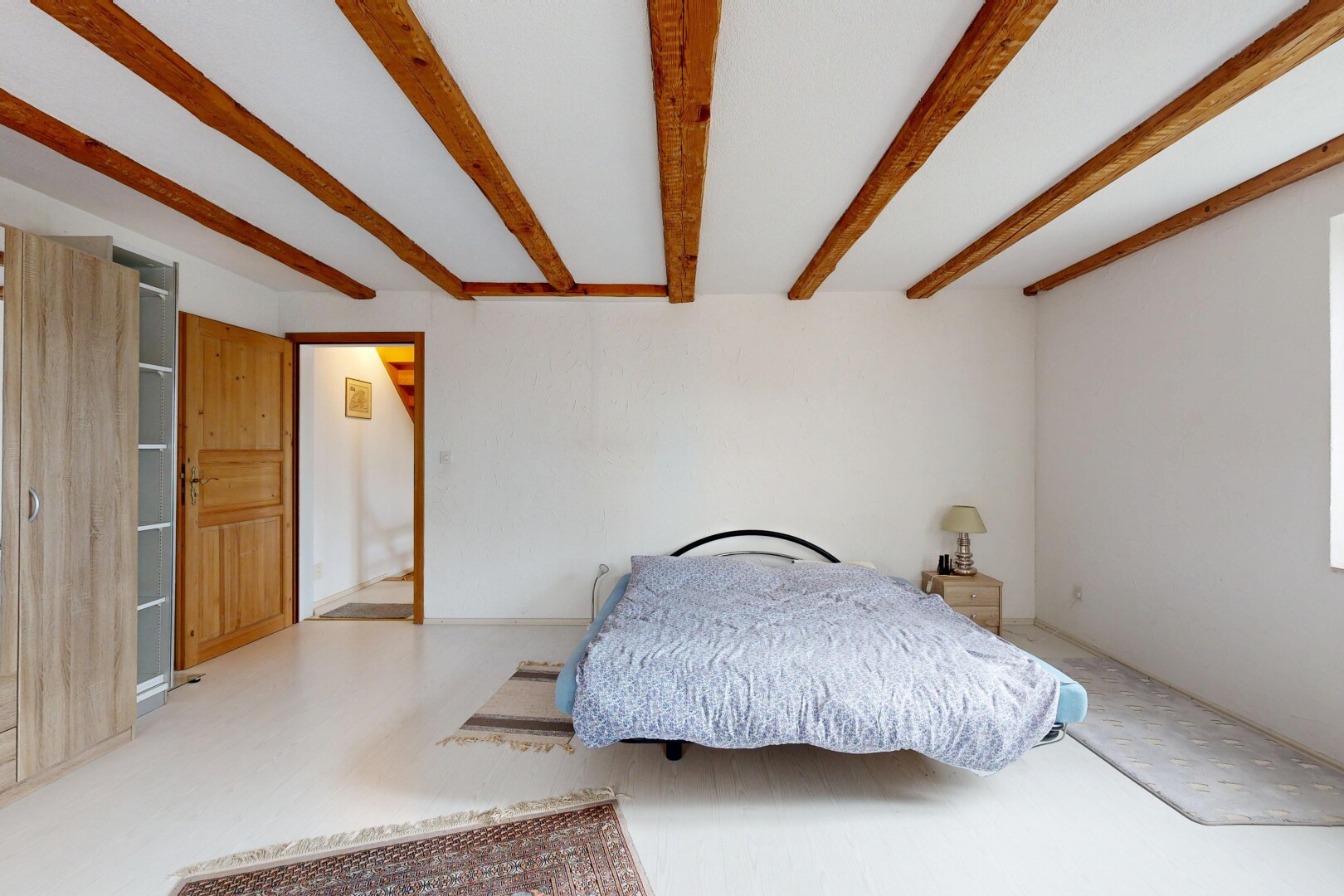 chambre avec inside property, cloison sèche, drywall, plafond à poutres, et beamed ceiling
