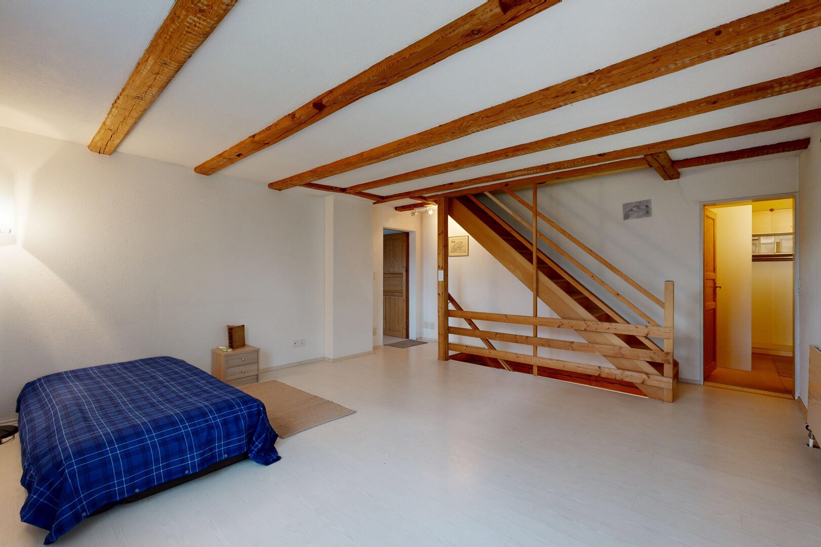 chambre avec inside property, beamed ceiling, plafond à poutres, drywall, et cloison sèche