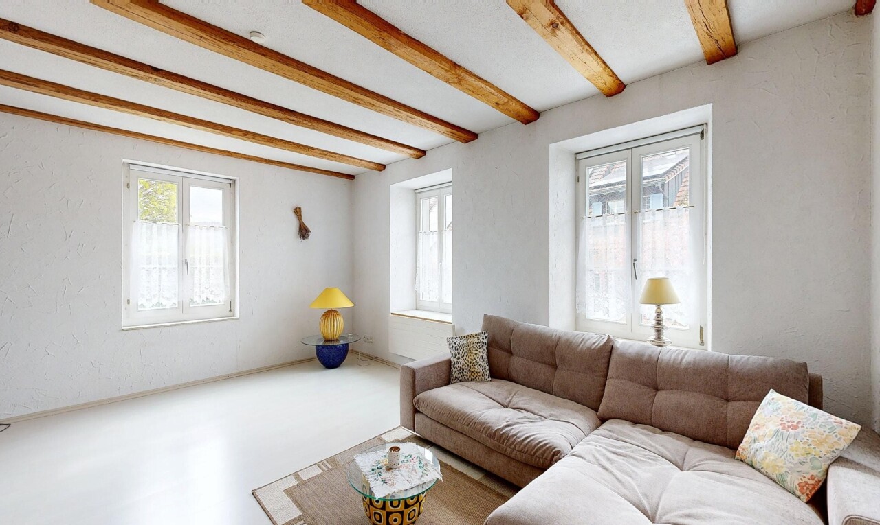 salon avec inside property, natural light, lumière naturelle, beamed ceiling, et plafond à poutres