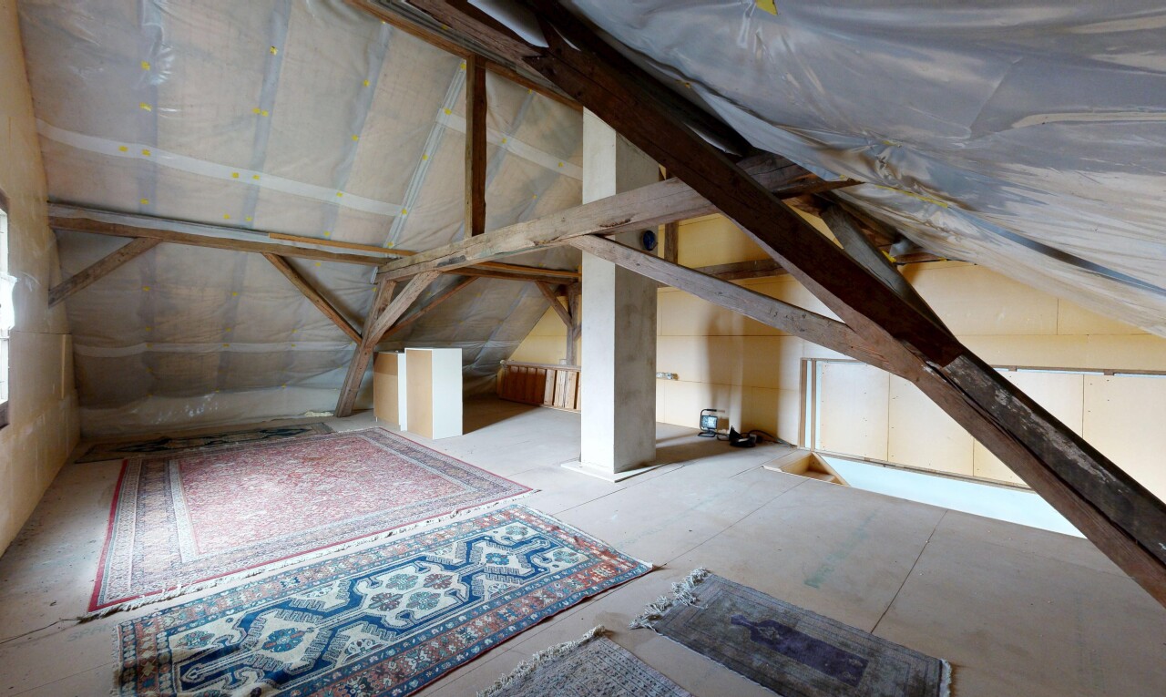 pièce vide avec unfinished floor, inside property, plafond voûté, et vaulted ceiling