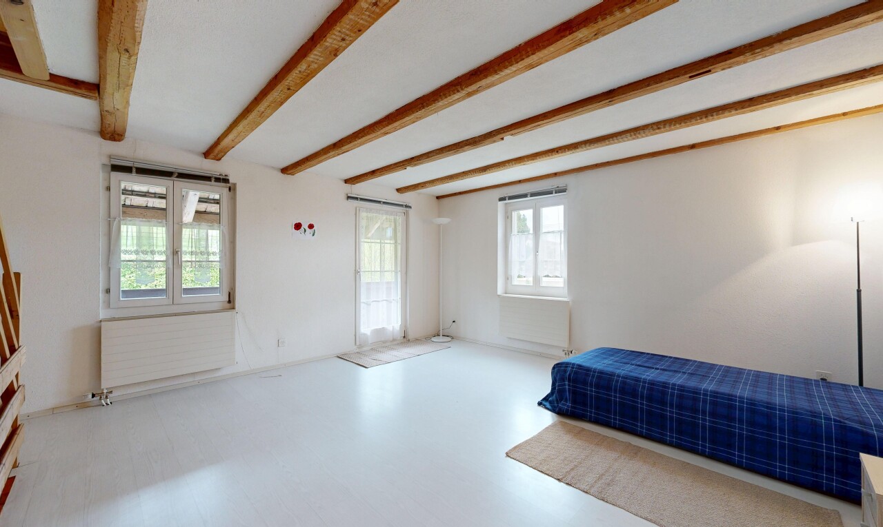 chambre avec inside property, beamed ceiling, plafond à poutres, drywall, et cloison sèche