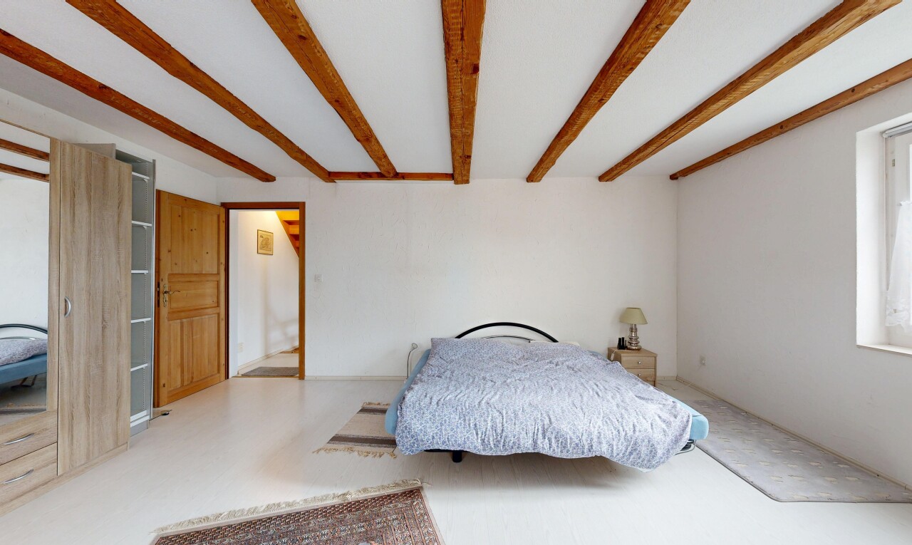 chambre avec inside property, cloison sèche, drywall, plafond à poutres, et beamed ceiling