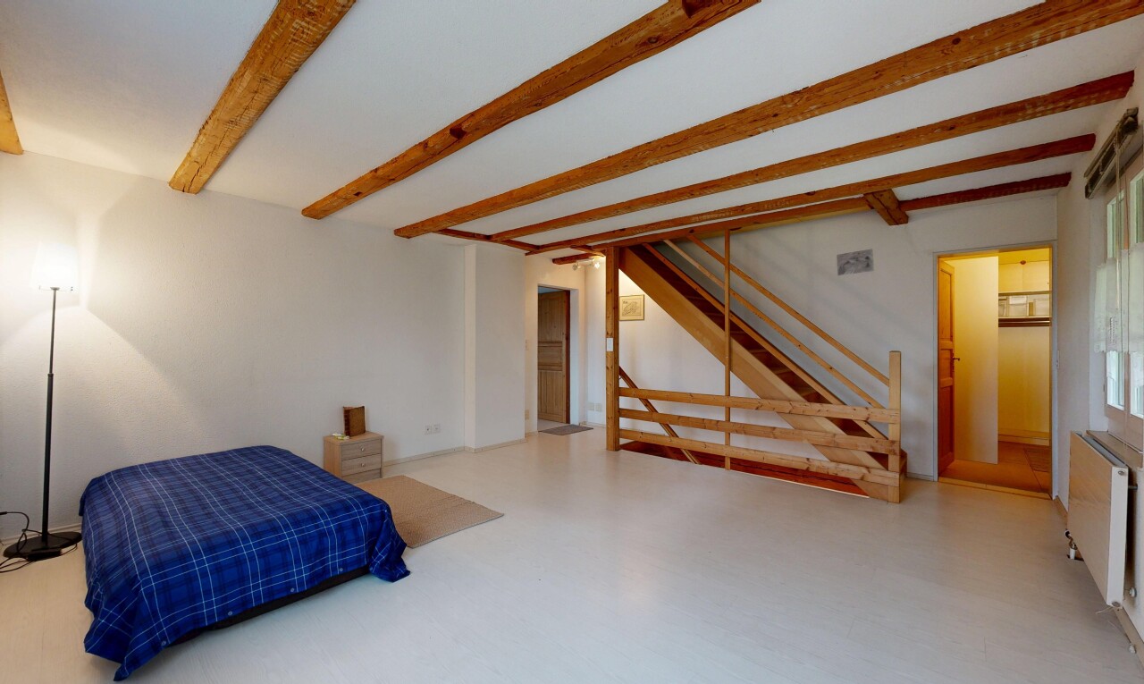 chambre avec inside property, beamed ceiling, plafond à poutres, drywall, et cloison sèche