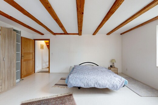 chambre avec inside property, cloison sèche, drywall, plafond à poutres, et beamed ceiling