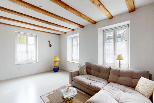 salon avec inside property, natural light, lumière naturelle, beamed ceiling, et plafond à poutres