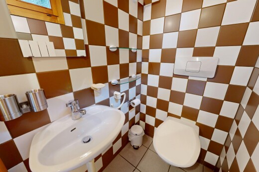salle de bains avec toilette, évier, inside property, mur en carrelage, et tile wall
