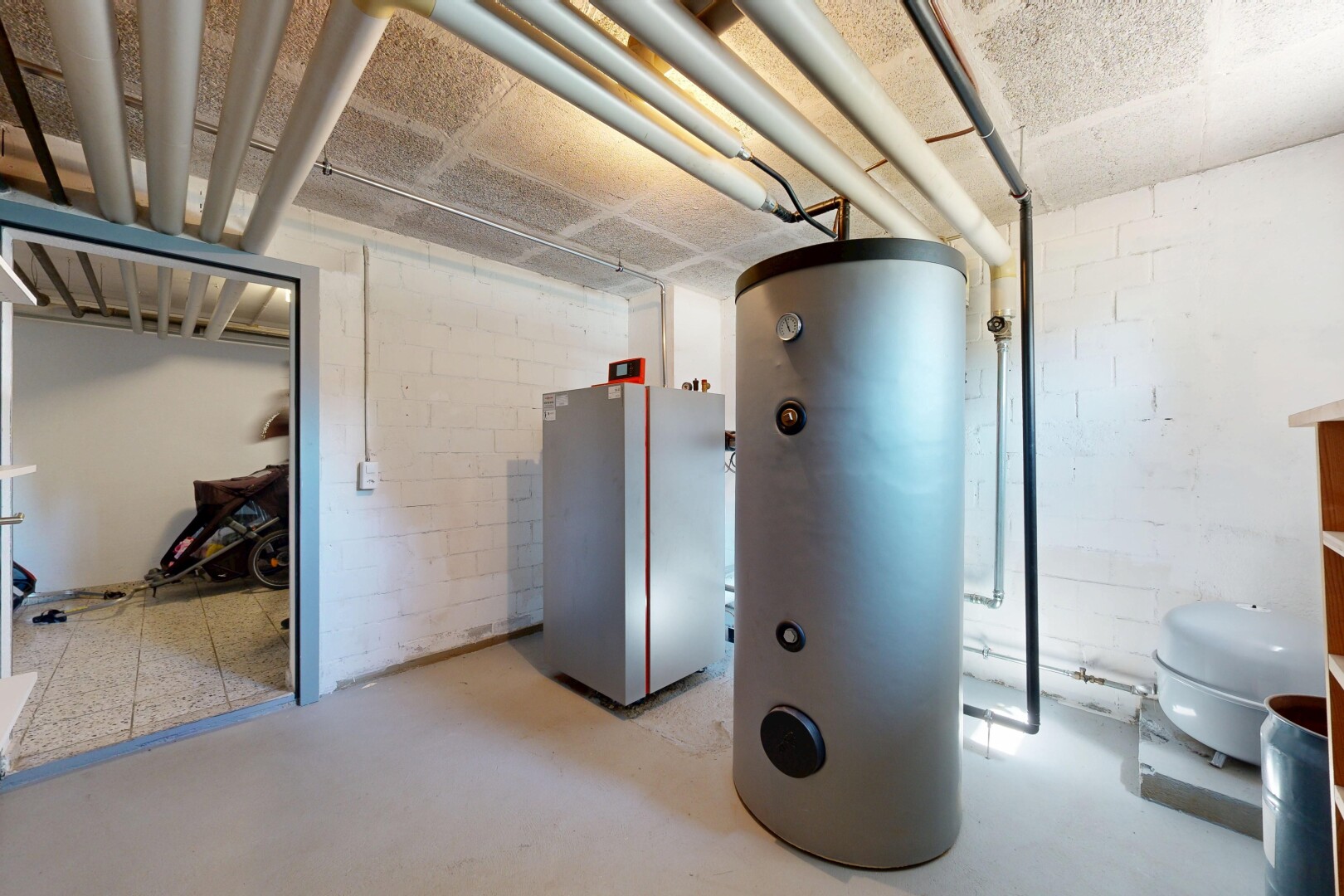 interior space featuring water heater, concrete block wall, and concrete floors