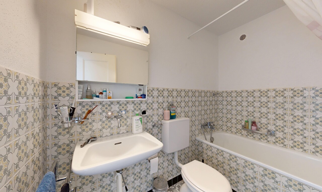 full bathroom featuring tile walls and wainscoting