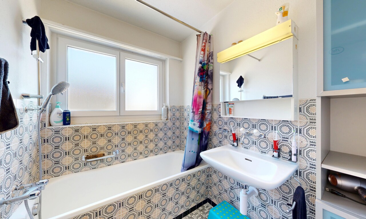 full bath with tiled shower / bath combo and tile walls
