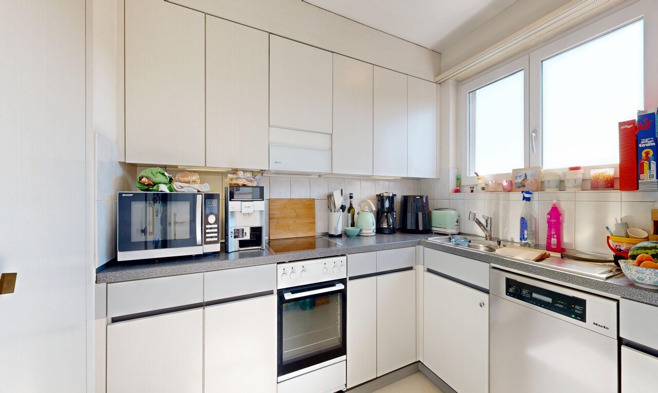 kitchen featuring stainless steel dishwasher, white oven, tasteful backsplash, white cabinetry, and dark countertops