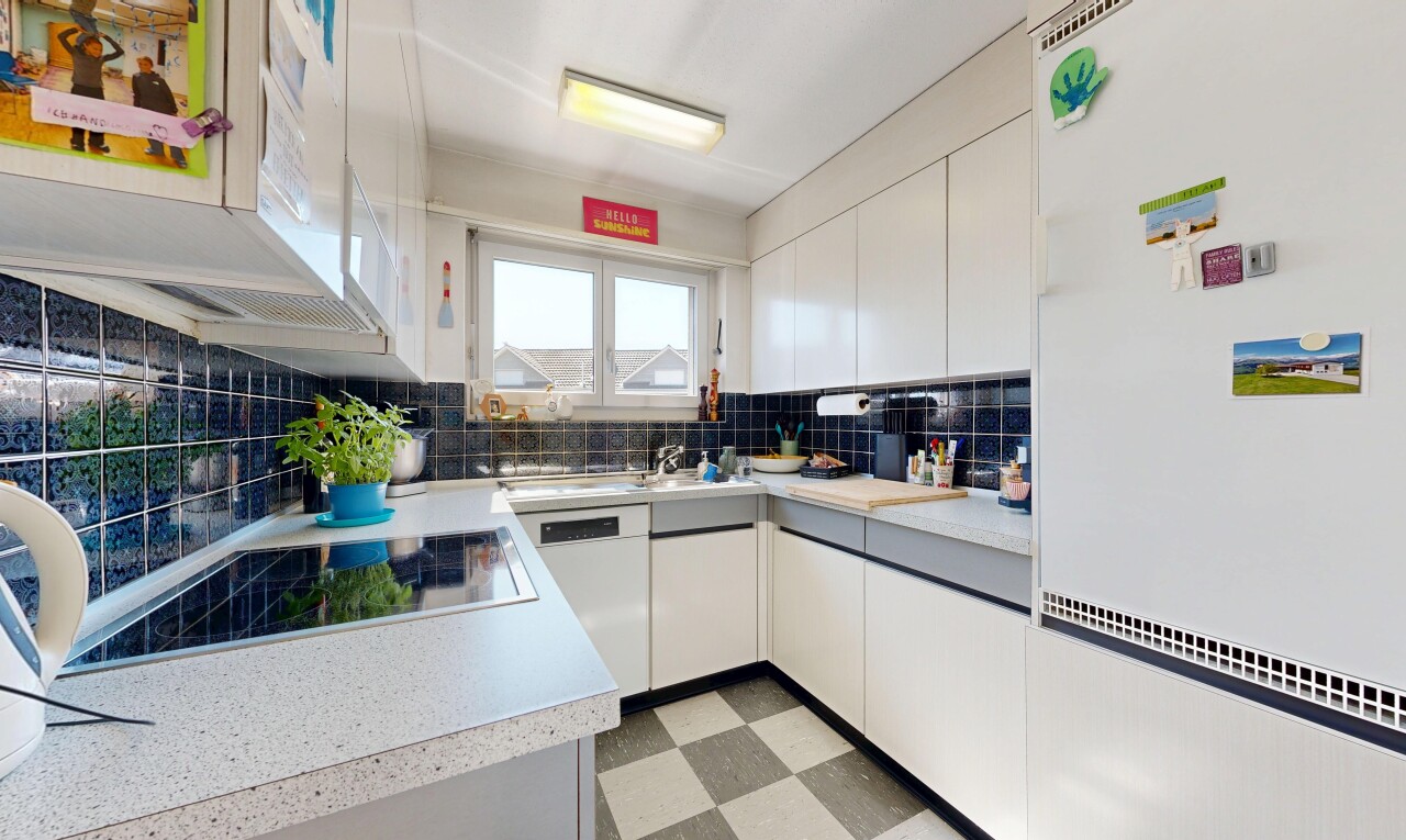 kitchen with white appliances, light countertops, and white cabinetry