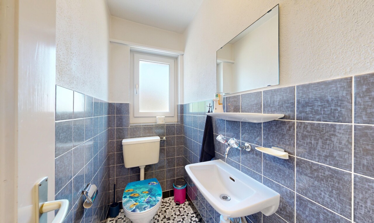 bathroom featuring tile walls, wainscoting, tile patterned flooring, and a textured wall