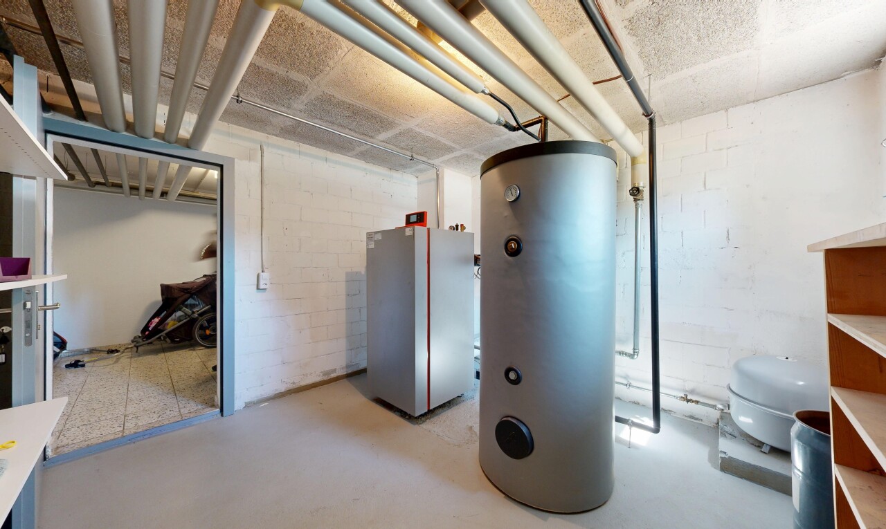 interior space featuring water heater, concrete block wall, and concrete floors