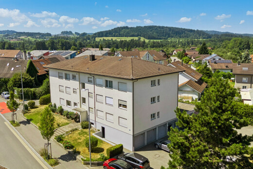 extérieur du bâtiment avec éclairage public, day time, garage intégré, et drone view