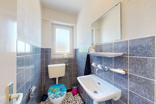 bathroom featuring tile walls, wainscoting, tile patterned flooring, and a textured wall
