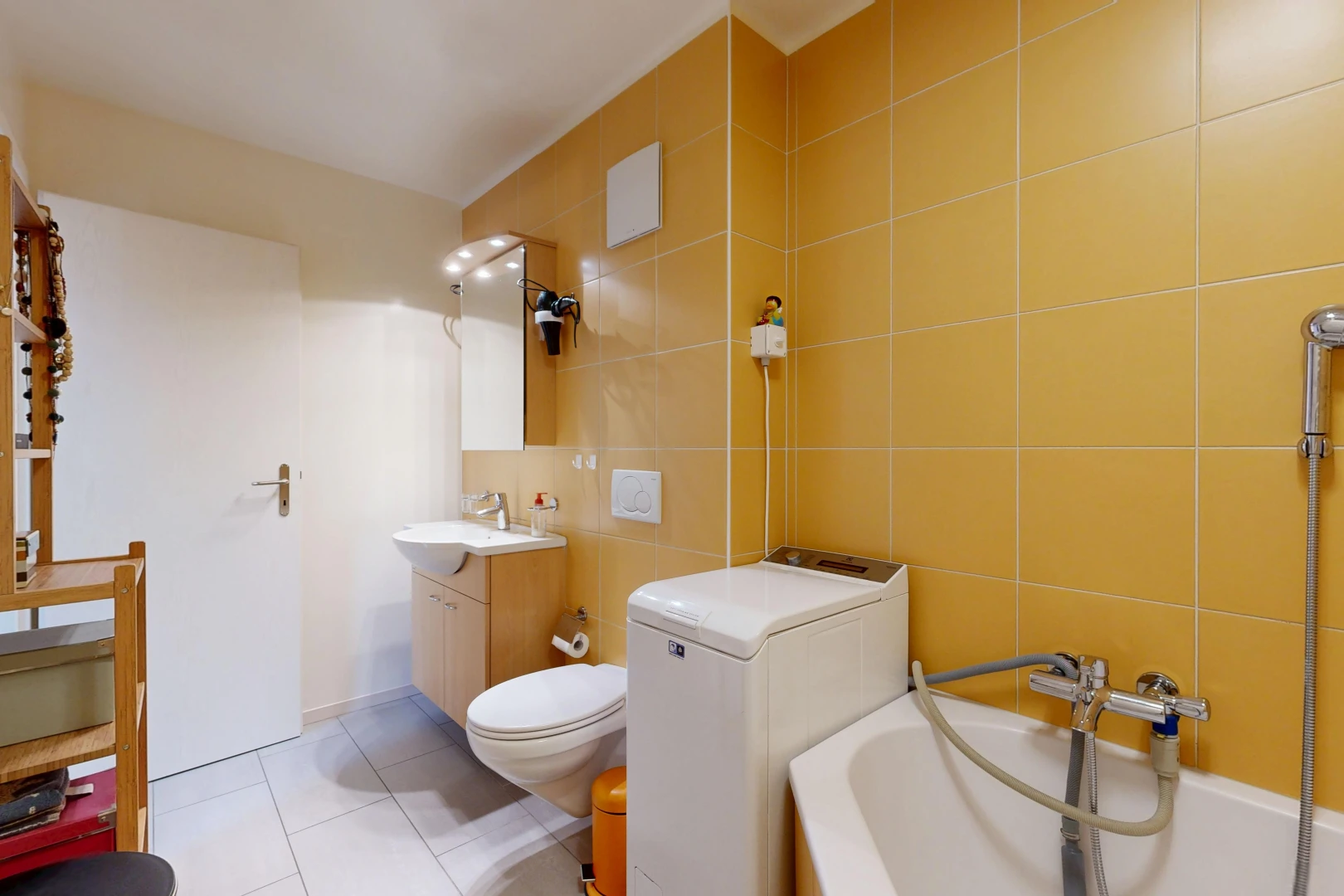full bath with tile walls, light tile patterned flooring, vanity, and washtub / shower combination