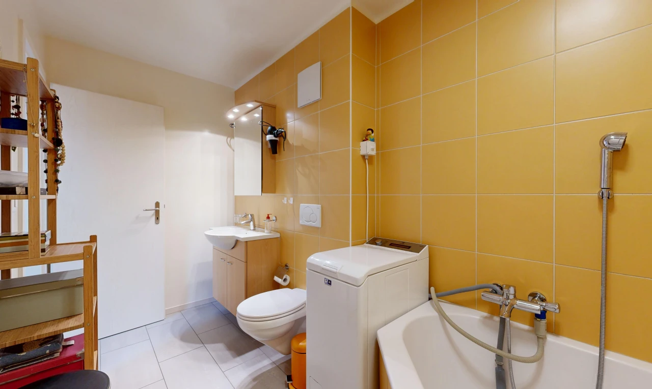 full bath with tile walls, light tile patterned flooring, vanity, and washtub / shower combination