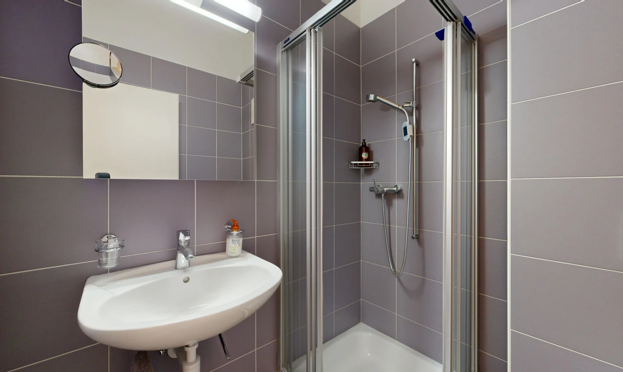 bathroom featuring a stall shower and tile walls