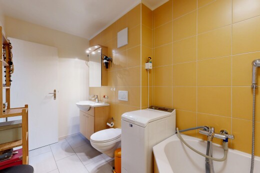 full bath with tile walls, light tile patterned flooring, vanity, and washtub / shower combination