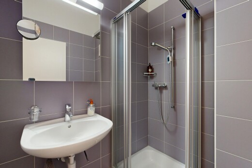 bathroom featuring a stall shower and tile walls