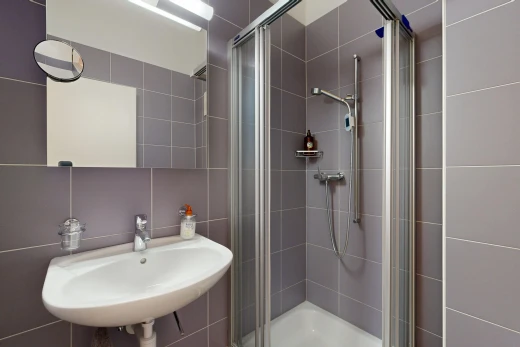 bathroom featuring a stall shower and tile walls