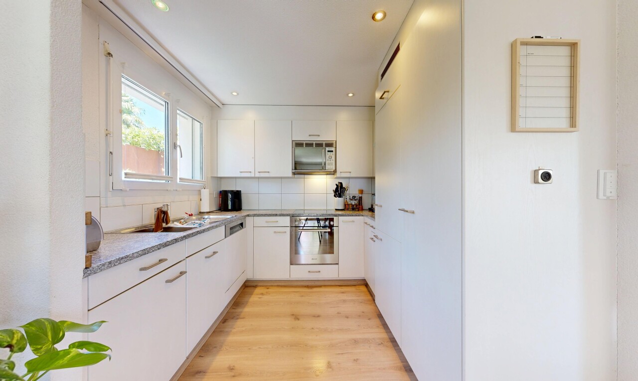 cuisine avec four, wood finish floor, sol en finition bois, light countertops, et recessed lighting