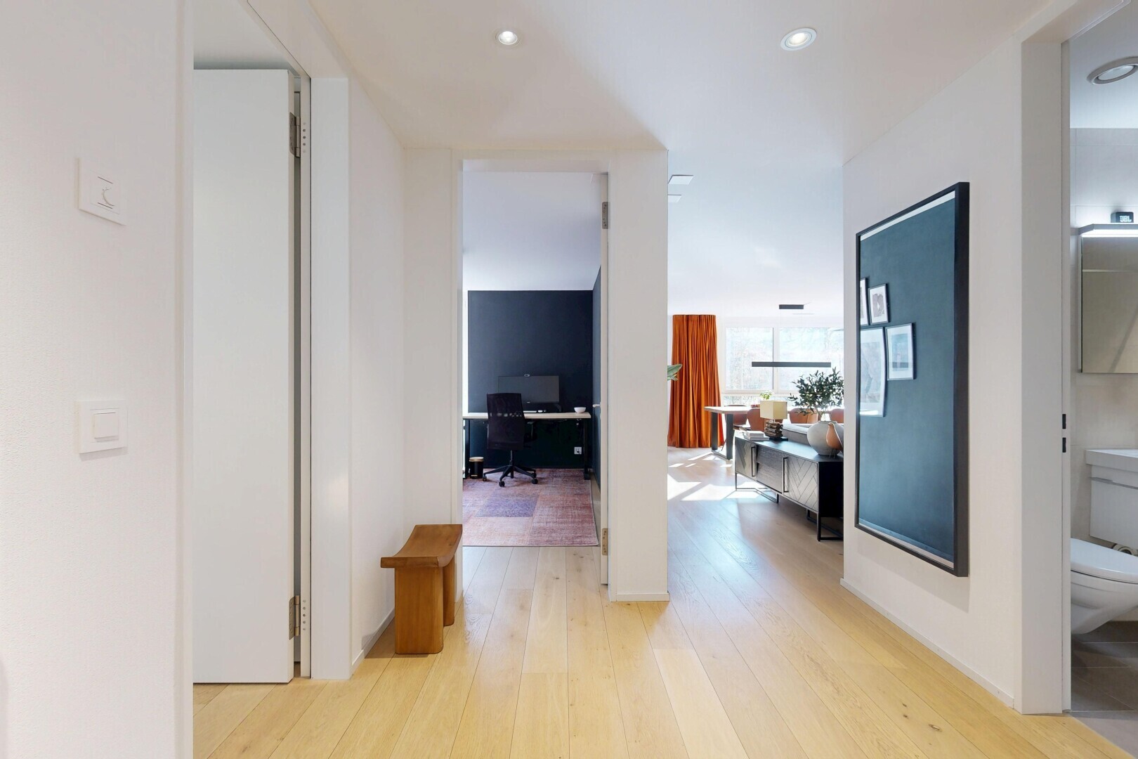 corridor with an office area and light wood finished floors