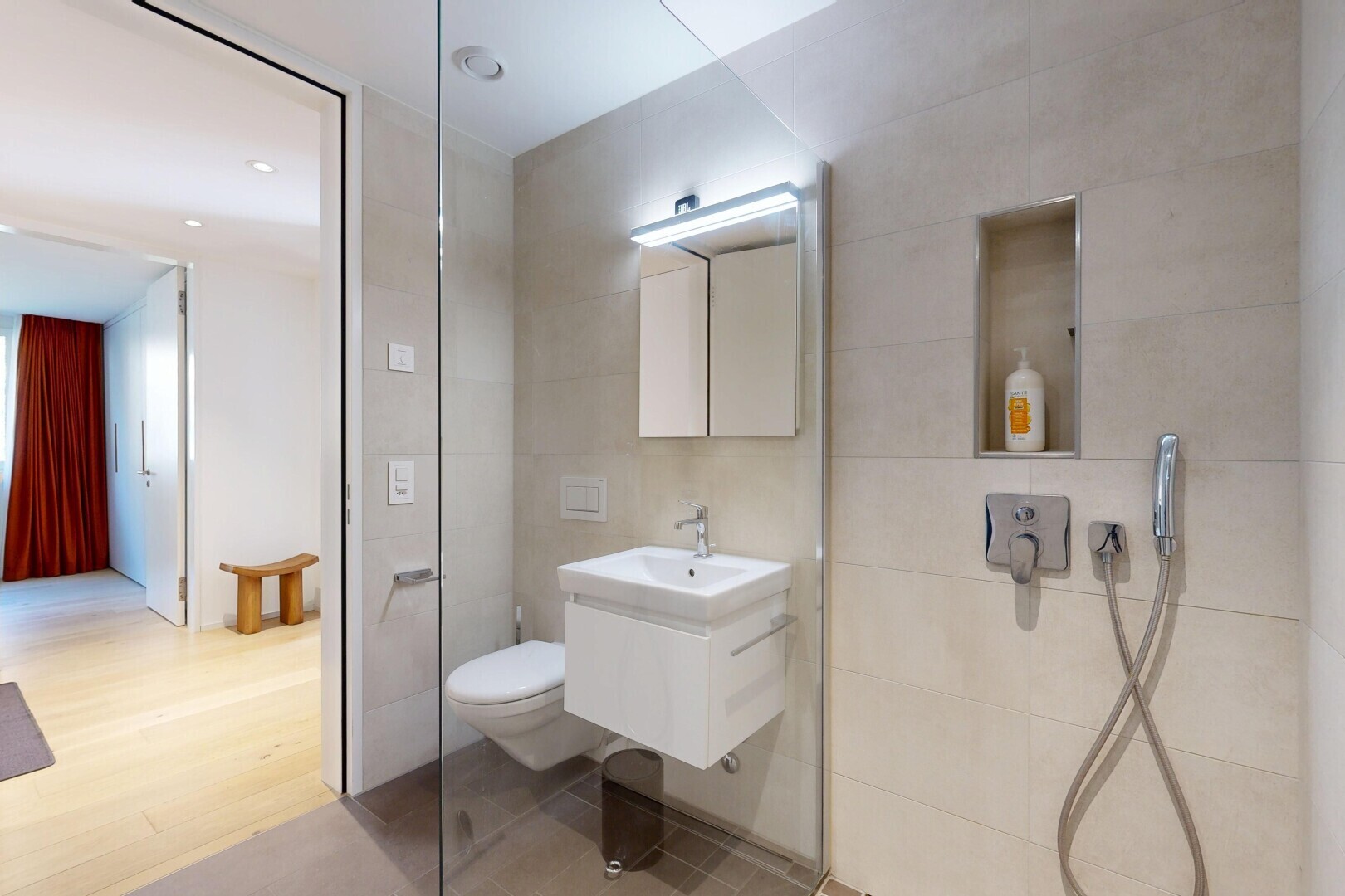 bathroom featuring tile walls, vanity, a walk in shower, and wood finished floors
