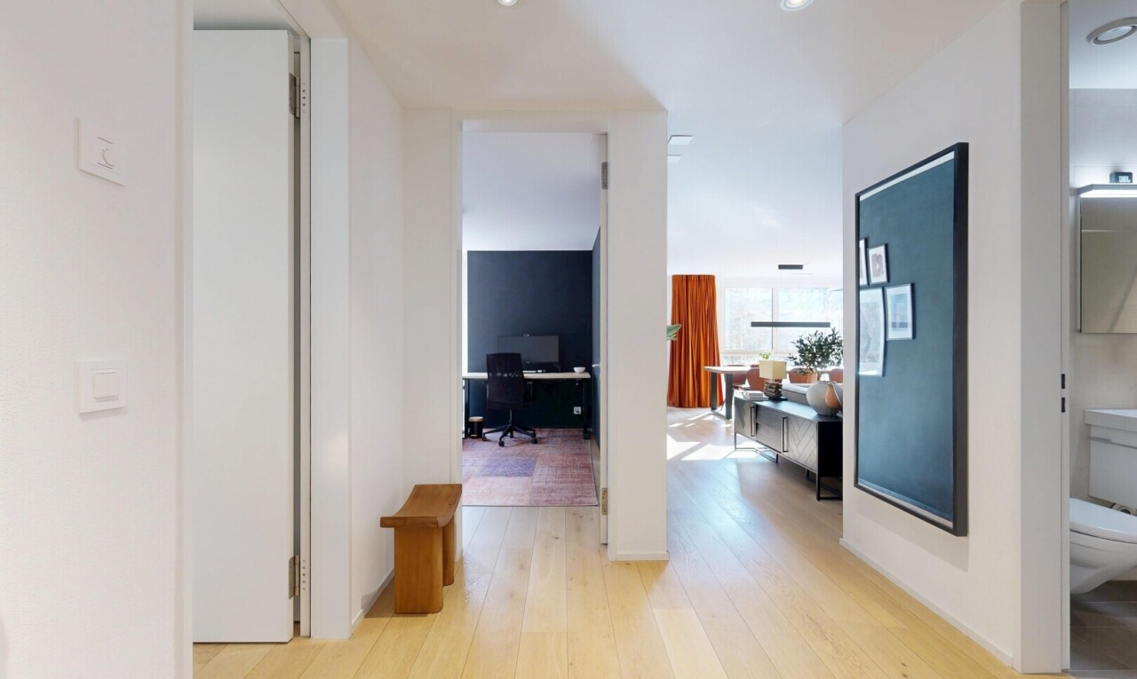 corridor with an office area and light wood finished floors