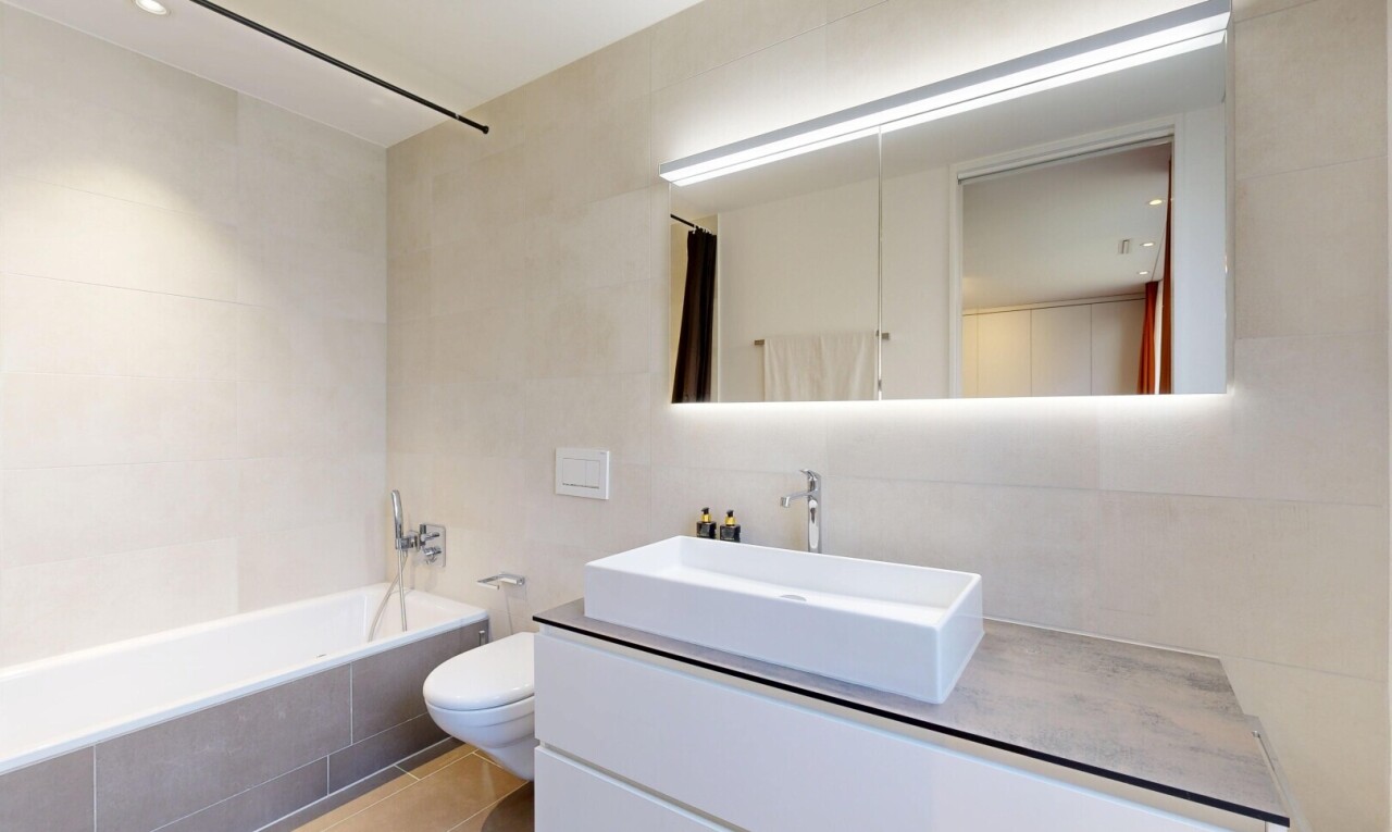 full bath with tiled shower / bath combo, vanity, tile walls, and light tile patterned flooring