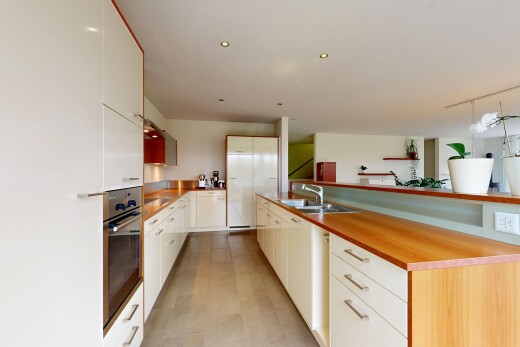 cuisine avec four, armoires blanches, armoires à panneau plat, inside property, et évier