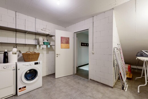 buanderie avec inside property, mur en blocs de béton, concrete block wall, lave-linge et sèche-linge séparés, et sol en carrelage