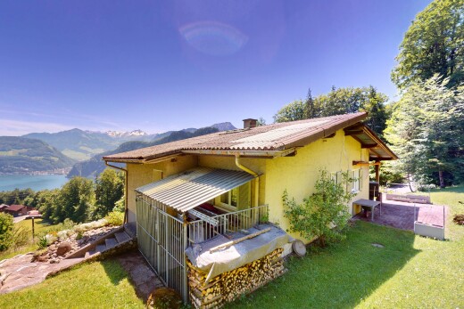 außenansicht mit mountain view, blick auf die berge, property visible, stuckverkleidung, und schornstein