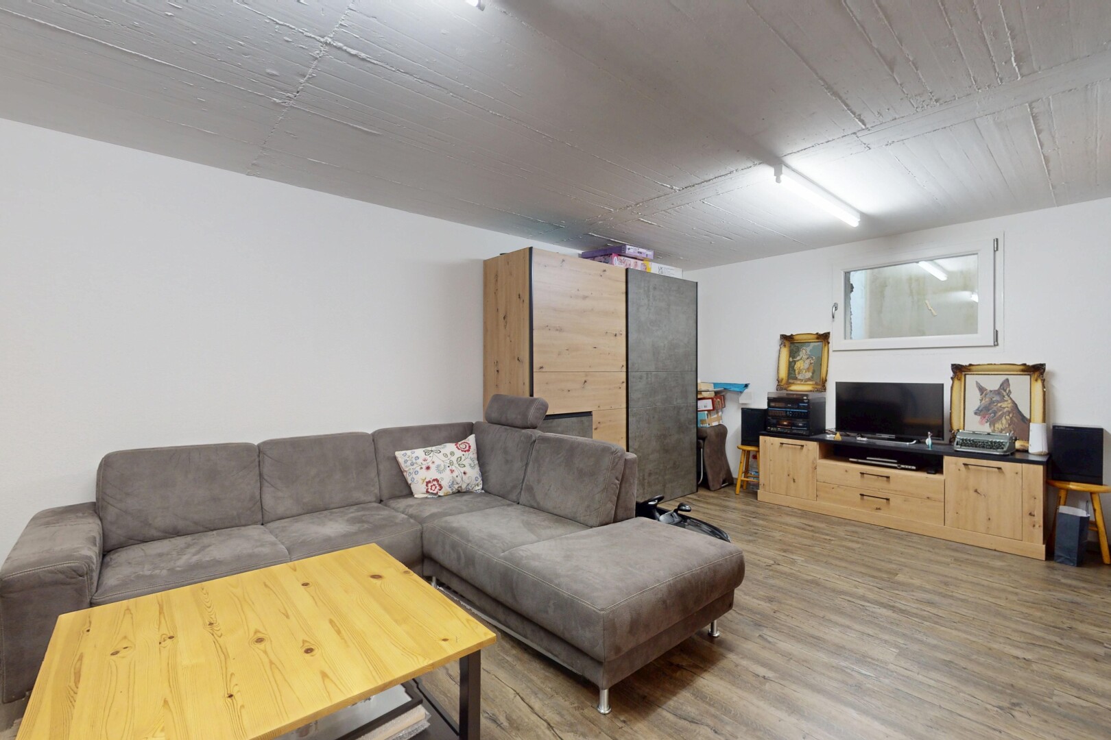 salon avec télévision, drywall, cloison sèche, wood finish floor, et sol en finition bois
