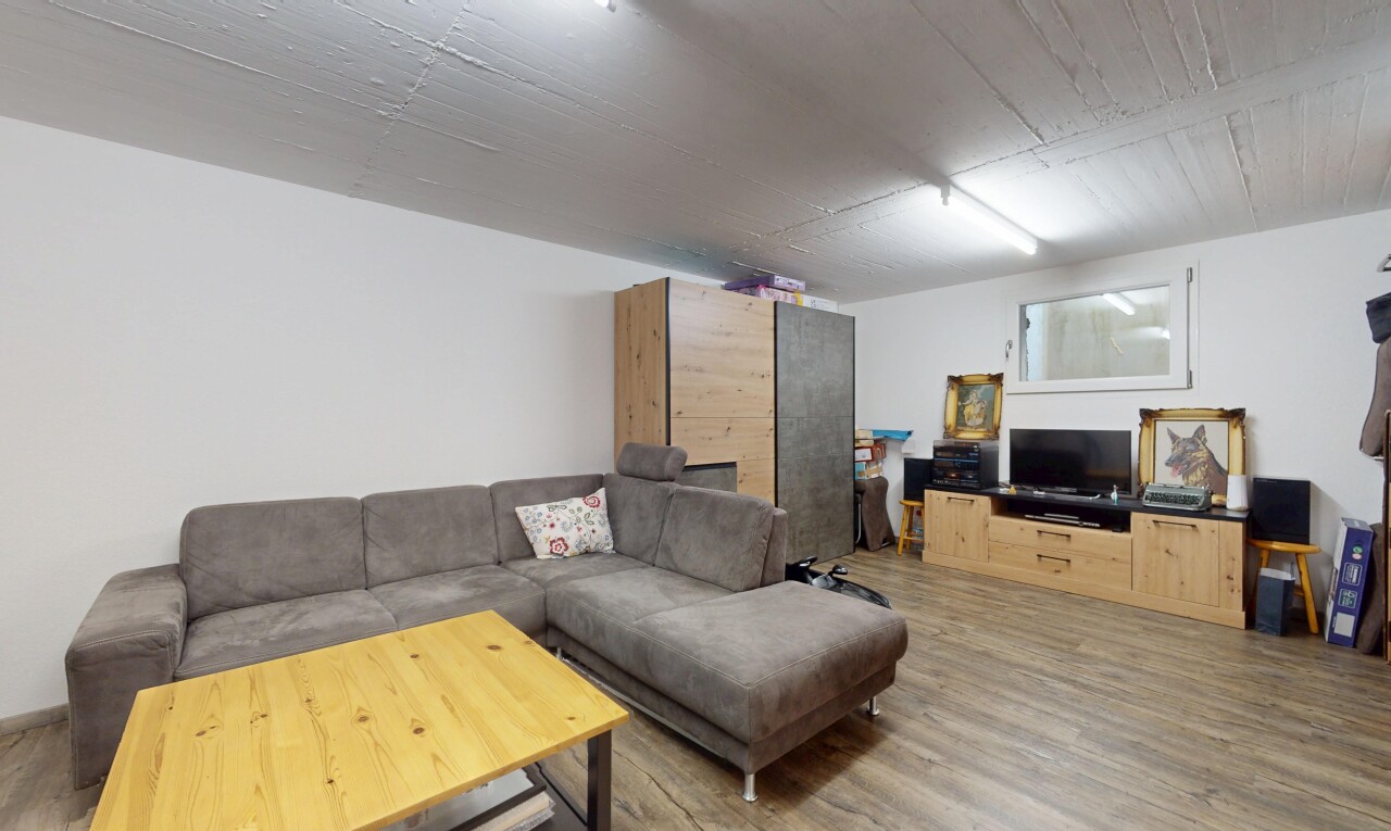 salon avec télévision, drywall, cloison sèche, wood finish floor, et sol en finition bois