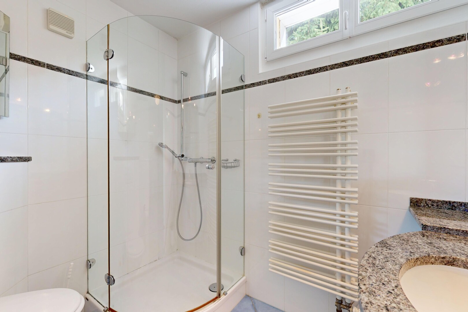 salle de bains avec radiateur, chauffe-serviettes, tile wall, mur en carrelage, et douche