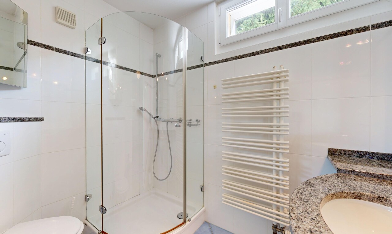 salle de bains avec radiateur, chauffe-serviettes, tile wall, mur en carrelage, et douche