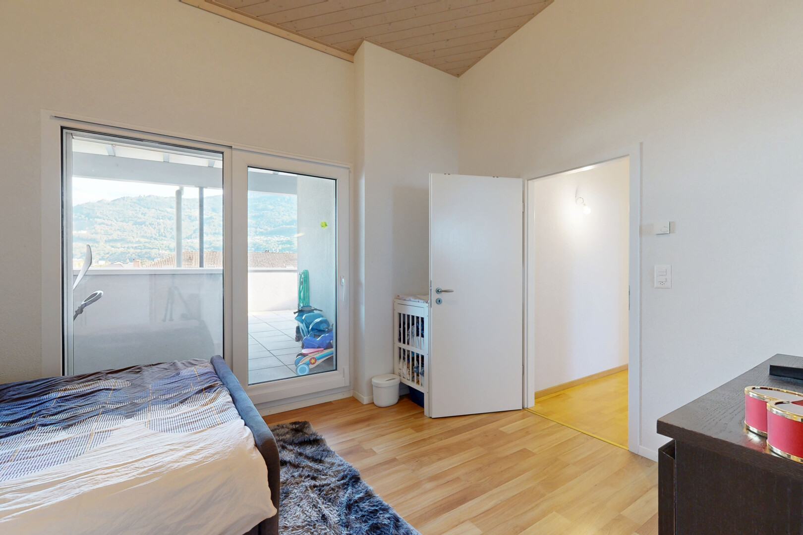 chambre avec high ceiling, plafond haut, drywall, cloison sèche, et wood finish floor