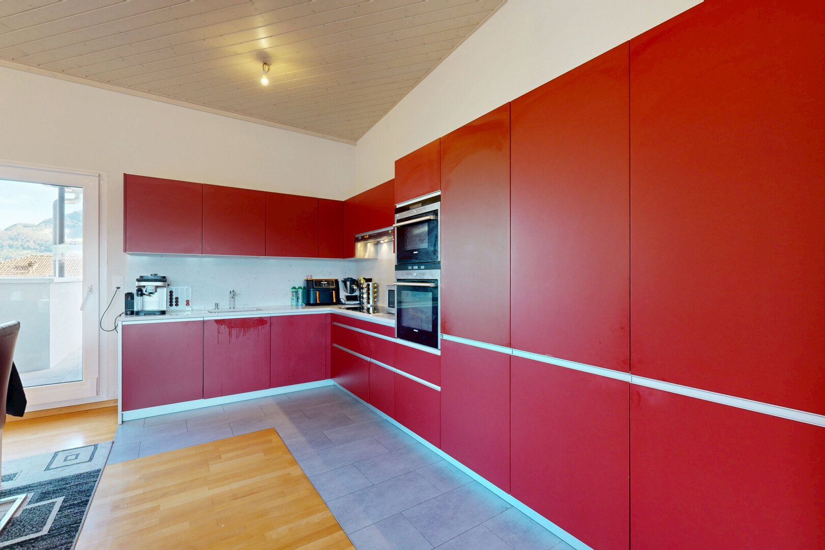 cuisine avec light countertops, plans de travail, light floor, évier, et flat panel cabinets