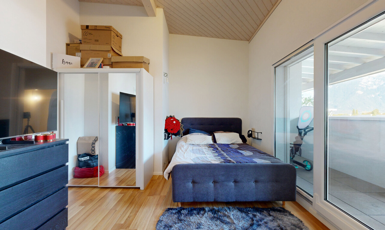 chambre avec cloison sèche, drywall, télévision, sol en finition bois, et wood finish floor