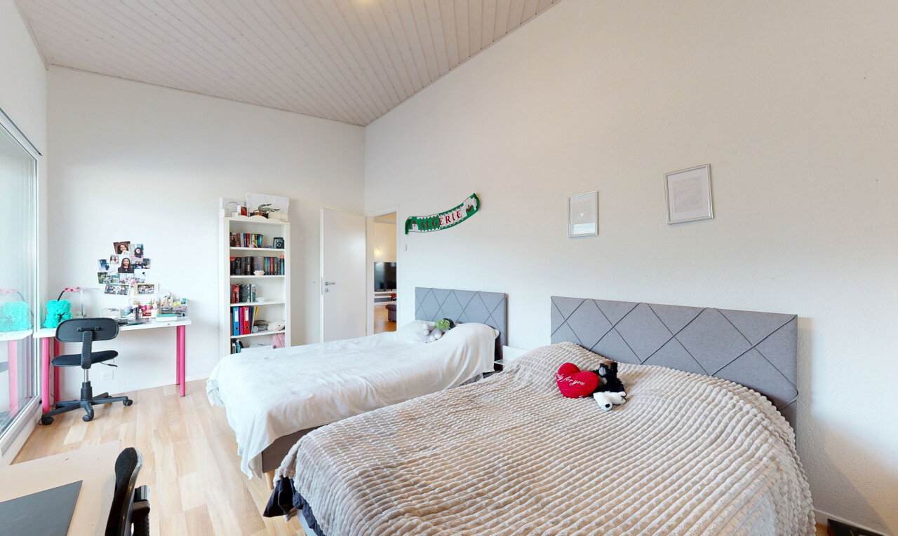 chambre avec espace bureau, drywall, cloison sèche, wood finish floor, et sol en finition bois