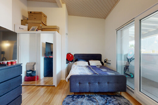 chambre avec cloison sèche, drywall, télévision, sol en finition bois, et wood finish floor
