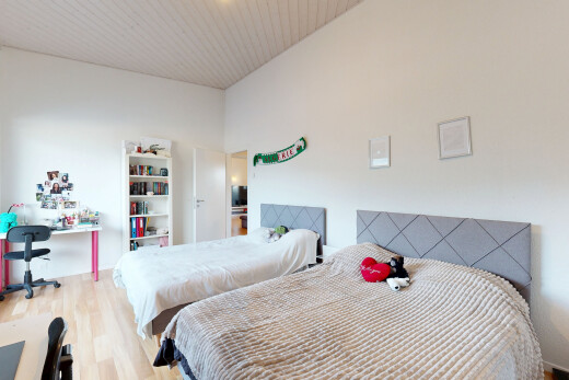 chambre avec espace bureau, drywall, cloison sèche, wood finish floor, et sol en finition bois